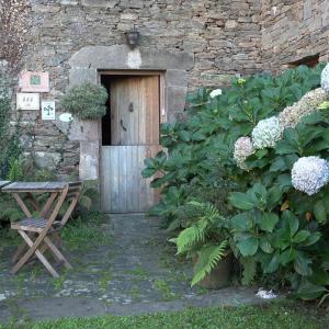 Entrada exterior con sillas de jardín y flores