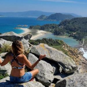 Mujer haciendo yoga con vistas al mar